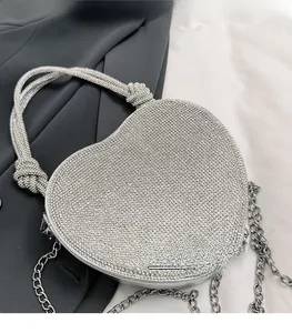 Détail du sac à main cœur en strass argenté avec poignée nouée et bandoulière chaîne