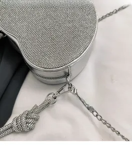 Gros plan détaillé du sac cœur en strass argenté avec fermoir mousqueton et chaîne métal