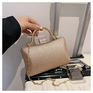 Macro detail of champagne gold sequin evening bag with metallic handle and crystal clasp