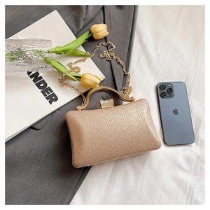 Macro view of champagne gold sequin clutch bag with metallic handle and diamond clasp