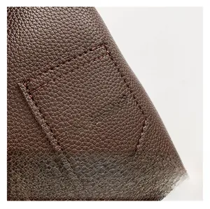 Detail view of dark brown lychee pattern leather with white Fashion & Bags text print