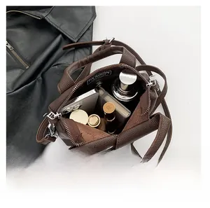 Internal view of dark brown bucket bag showing capacity for phone and cosmetics
