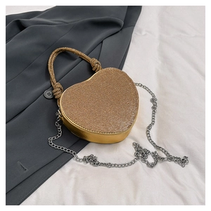 Vue détaillée du sac de soirée en forme de cœur avec strass dorés et poignée perlée
