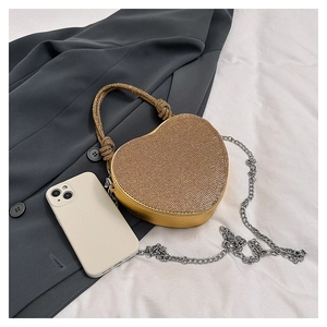 Détail du sac de soirée en forme de cœur avec strass dorés et bandoulière chaîne