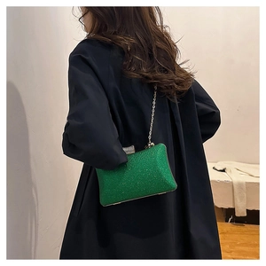 Detail of green sequin evening bag with gold chain and rhinestone clasp