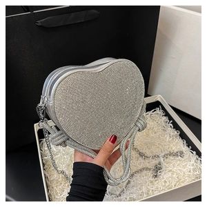 Détail de la pochette de soirée en forme de cœur argenté avec strass brillants et chaîne