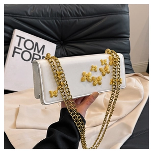 Detail showing 3D golden butterfly on white rectangular crossbody bag with chain strap