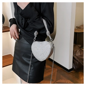 Détail du sac de soirée argenté en forme de cœur avec strass et une chaîne en métal