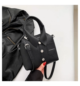 Detail of black shirt-shaped PU leather bag featuring decorative buttons and mini pocket
