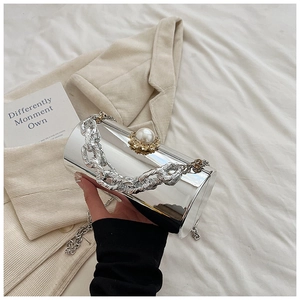 Close-up of silver mirror acrylic bag with oversized pearl clasp and chunky chain handle