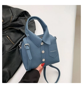Detail showing creative shirt-shaped bag with silver buttons and litchi texture