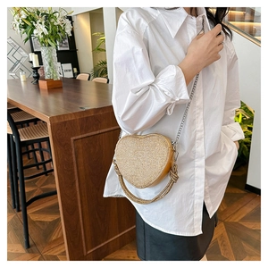 Détail du sac de soirée doré en forme de cœur avec strass scintillants et franges en métal