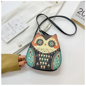 Detail of cute owl shaped crossbody bag with colorful printed patterns and black PU strap