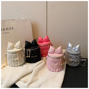 Détail des mini sacs seaux cylindriques avec nœuds et broderie cœur élégante