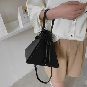 Minimalist black triangular leather handbag with adjustable strap and side bow detail
