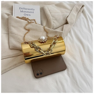 Detail of gold acrylic cylinder evening bag with pearl clasp and dual chain straps
