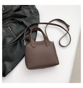 Close-up of brown litchi pattern leather bag with silver metal zipper and hardware