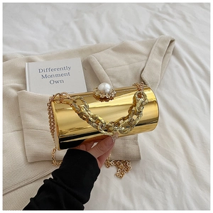 Close-up of golden acrylic cylinder bag with pearl rhinestone clasp and chunky chain