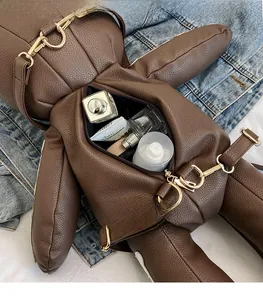 Detail of bear-shaped leather backpack showing spacious interior for daily cosmetics