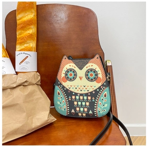 Detailed view of the ethnic owl pattern and PU leather texture on the small round bag