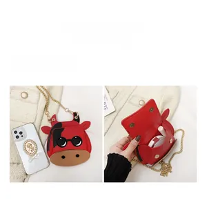 Detailed view of mini cow-shaped shoulder bag interior capacity and metal chain