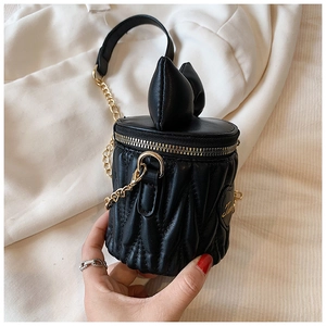 Détail du mini sac rond noir avec nœud 3D et texture plissée en cuir synthétique