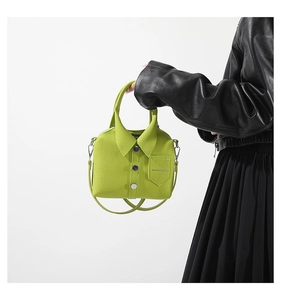 Detail of neon green shirt-shaped mini bag featuring silver buttons and leather texture