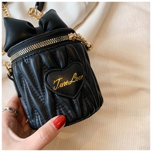 Détail d'un mini sac cylindre noir matelassé avec nœud et broderie cœur True Love