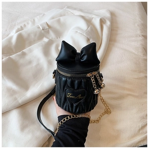 Détail du sac cylindre noir matelassé avec nœud papillon et broderie True Love dorée