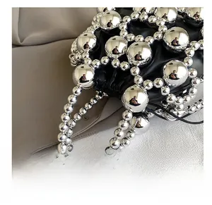 Detail shot of mini black bag with silver metallic bead weaving and beaded handle