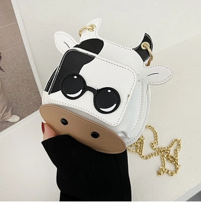 Detail of mini cow-print crossbody bag featuring cartoon sunglasses and gold chain