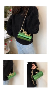 Detail of green acrylic mirror cylinder bag with gold chain and pearl clasp closure