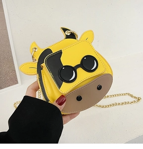 Close-up of yellow cartoon cow crossbody bag with sunglasses and gold chain strap