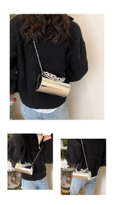 Detail of cylinder mirror evening bag with gold chain strap and reflective metallic finish