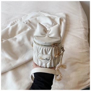 Détail du mini sac rond blanc avec broderie coeur matelassée et nœud décoratif