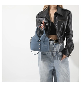 Detail of creative shirt-shaped crossbody bag in dark blue PU leather with rivets