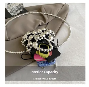 Internal capacity of mini black bucket bag with silver beads showing space for makeup