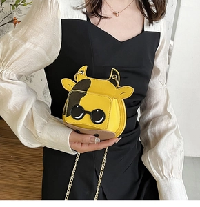 Detail of mini cow-shaped shoulder bag in yellow PU leather with gold chain strap