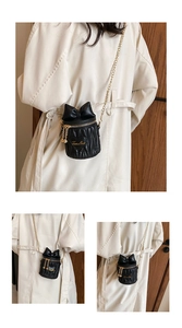 Détail du mini sac seau matelassé noir avec nœud, patch cœur et bandoulière chaîne