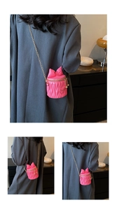 Vue détaillée du mini sac seau rose matelassé avec nœud et bandoulière chaîne