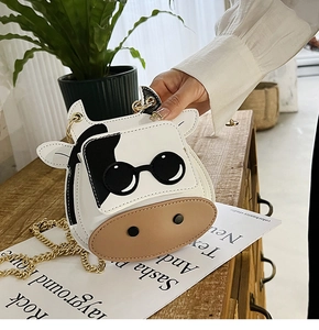 Detailed view of mini cow-shaped chain bag with cute sunglasses design and black-white leather