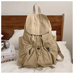 Detail of drawstring closure and large capacity storage on the beige nylon backpack