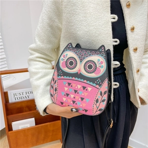 Cute owl-shaped mini crossbody bag with glitter finish on a stylish fashion model
