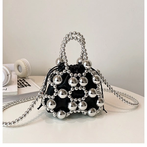 Detailed view of mini bucket bag featuring silver metallic beads and black inner drawstring