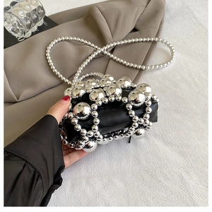 Detail of mini black woven bag with silver beads and metallic pearl shoulder strap
