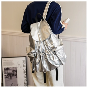 Detail of silver metallic backpack with drawstring texture and waterproof fabric finish