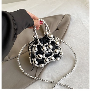 Detail of silver beaded mini crossbody bag with a black leather drawstring pocket