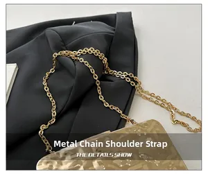Detail of golden metal chain strap on an amber shell clutch evening bag with ice crackle texture