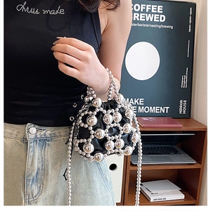 Close-up of metallic beaded crossbody bucket bag with silver hollow-out design
