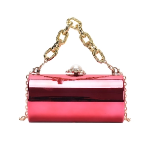 Glossy magenta acrylic cylinder bag with gold chain handle and pearl clasp detail